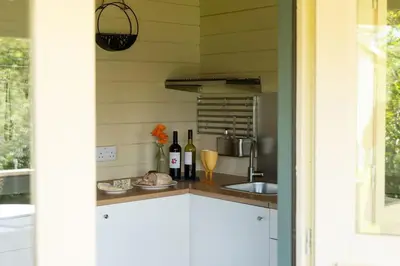 a kitchen with a sink and a counter with wine bottles at Safari Cornwall in Bodmin