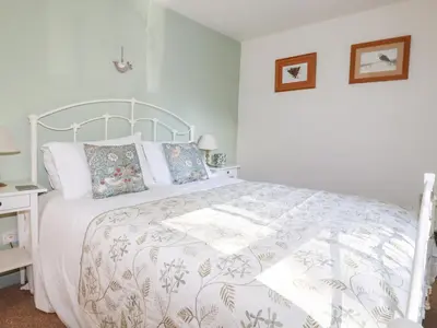 a bedroom with a bed with a white bedspread at The Mews in Bodmin
