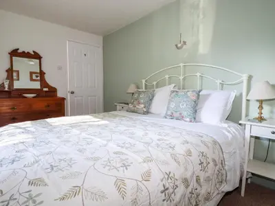 a bedroom with a bed with a white bedspread at The Mews in Bodmin