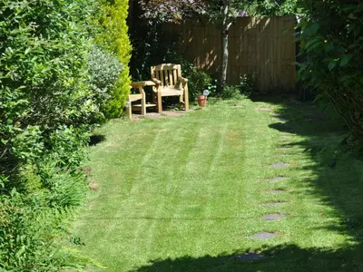 a lawn with a chair and a table in a yard at The Mews in Bodmin