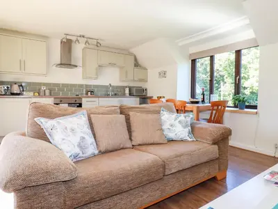 a living room with a couch and a kitchen at The Mews in Bodmin