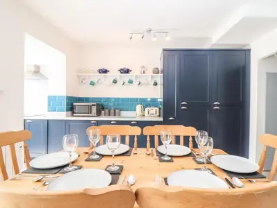 a dining room with a table with plates and wine glasses at Chy An Mor in Mevagissey