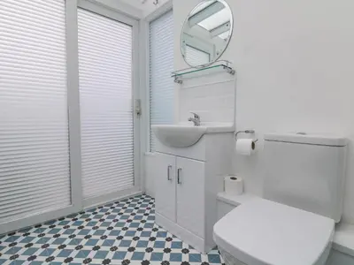 a bathroom with a toilet and a sink and a mirror at Chy An Mor in Mevagissey