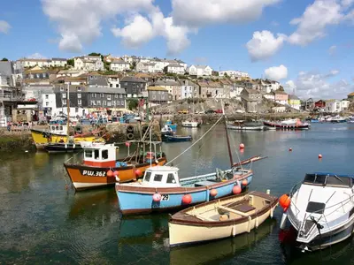 a group of boats are docked in a harbor at Chy An Mor in Mevagissey