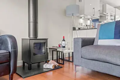 a living room with a fireplace and a couch at House 11 in Looe