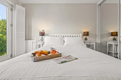 a white bed with a box of oranges on it at House 11 in Looe