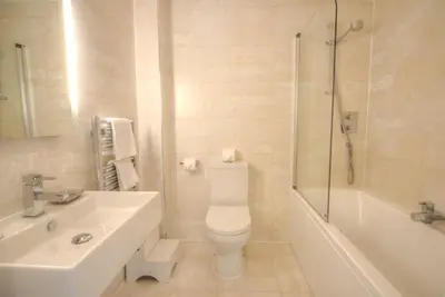 a bathroom with a toilet and a sink and a shower at House 11 in Looe