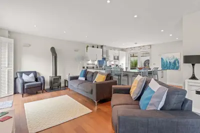 a living room with two couches and a kitchen at House 11 in Looe