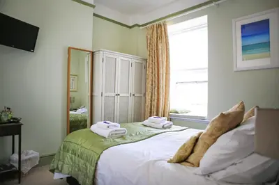 a bedroom with a bed with towels on it at Blue Sky Bed and Breakfast in St Ives