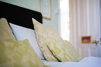 a pile of pillows sitting on top of a bed at Blue Sky Bed and Breakfast in St Ives