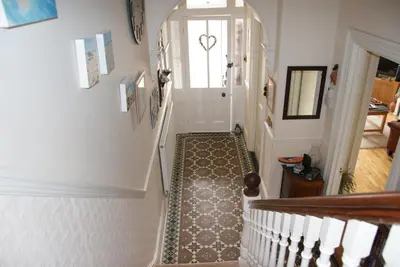 a hallway with a stairway with a door and a stairwayngthngthngth at Blue Sky Bed and Breakfast in St Ives