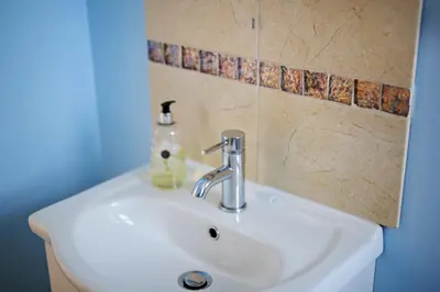 a white sink in a bathroom with a blue wall at Blue Sky Bed and Breakfast in St Ives