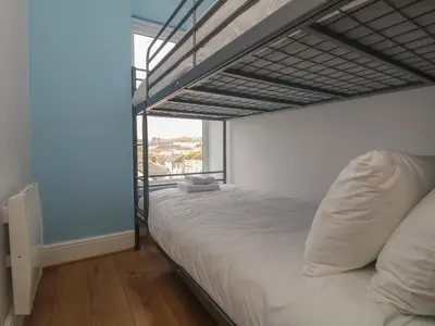 a bedroom with a bunk bed and a large window at Rock Lobster in Helston