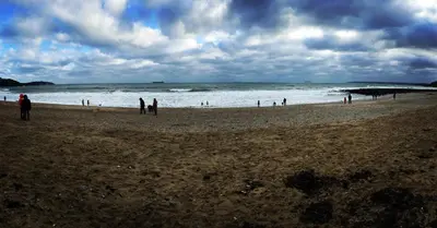 a group of people standing on a beach at Membly Hall Hotel in Falmouth