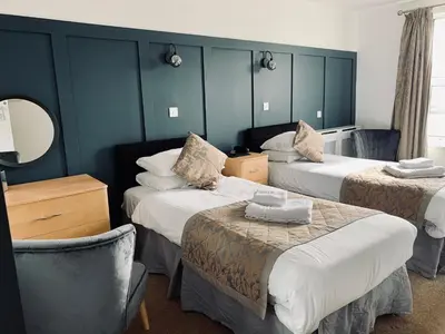 a hotel room with two beds and a mirror at Membly Hall Hotel in Falmouth