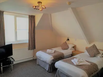 a hotel room with two beds and a television at Membly Hall Hotel in Falmouth
