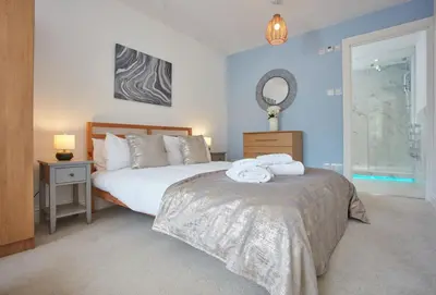 a bedroom with two beds and a mirror on the wall at Anneth Lowen in Polzeath