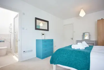 a bedroom with a blue bed and a blue dresser at Anneth Lowen in Polzeath