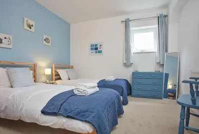 a bedroom with two beds and a window at Anneth Lowen in Polzeath