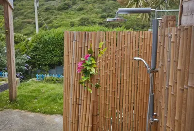 a fence with a pink flower hanging on it at Anneth Lowen in Polzeath
