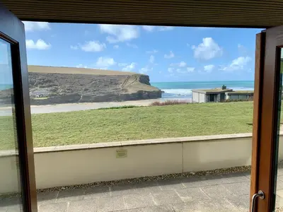a view of the ocean from a sliding glass door at White Lodge - Coast Hideaways in Mawgan Porth