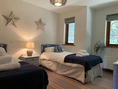 a bedroom with two beds and stars on the wall at White Lodge - Coast Hideaways in Mawgan Porth