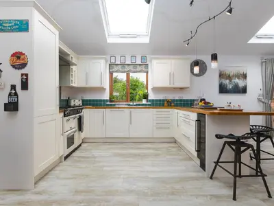 a kitchen with white cabinets and a large window at Branock, Tor Down Quarry in Bodmin