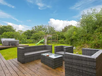a patio with two wicker chairs and a playground at Branock, Tor Down Quarry in Bodmin