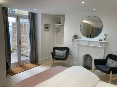 a bedroom with a bed and a mirror and a fireplace at Acuba in Falmouth