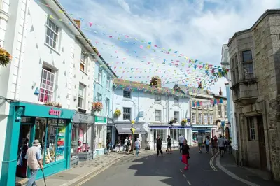 a group of people walking down a street with bunting at Acuba in Falmouth