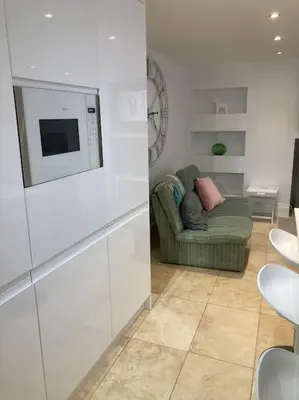 a living room with a couch and a microwave at Acuba in Falmouth