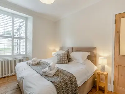 a bedroom with a bed with towels on it at Ivy Mount in Uny Lelant