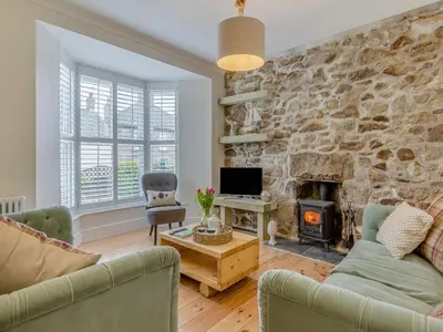 a living room with a stone wall at Ivy Mount in Uny Lelant