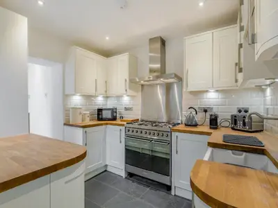 a kitchen with white cabinets and a stove top oven at Ivy Mount in Uny Lelant