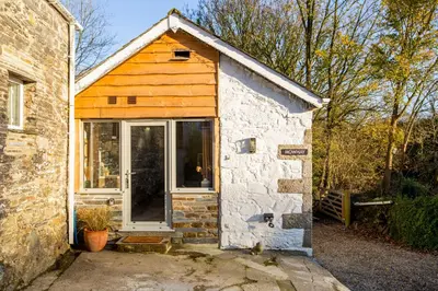 a small house with a door on the side of it at Mowhay Barn in Bodmin