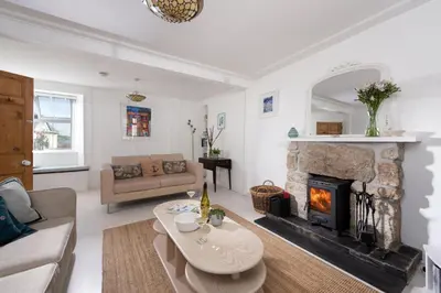 a living room with a couch and a fireplace at Rosevean in Marazion