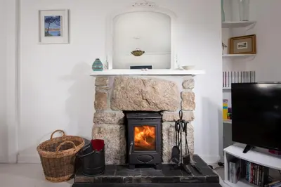 a fireplace in a living room with a tv at Rosevean in Marazion