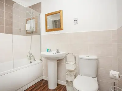 a white bathroom with a toilet and a sink at 4 Water Wheel Apartment in Charlestown