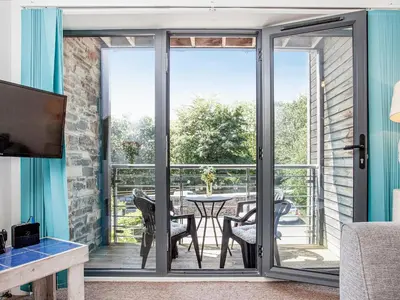 a living room with sliding glass doors leading to a patio at 4 Water Wheel Apartment in Charlestown