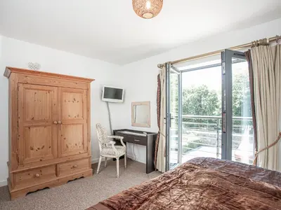 a bedroom with a bed and a desk and a window at 4 Water Wheel Apartment in Charlestown