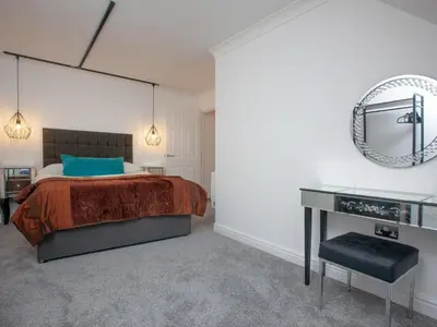 a bedroom with a bed and a desk and a mirror at Pochin House Apartment Penthouse in St Austell