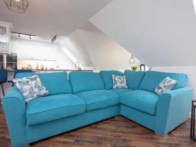 a blue couch sitting in a living room at Pochin House Apartment Penthouse in St Austell