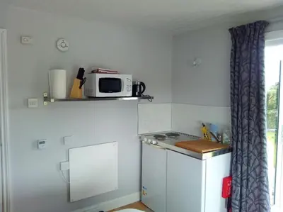 a kitchen with a microwave on top of a refrigerator at Hawk's Nest in Wadebridge