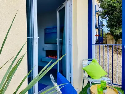 a patio with a table and chairs on a balcony at Oceano - Carbis bay, St Ives, 1 bed apartment with free parking near to the beach in St Ives
