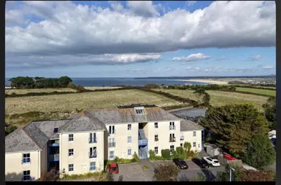 an aerial view of a large house with the ocean in the background at Oceano - Carbis bay, St Ives, 1 bed apartment with free parking near to the beach in St Ives