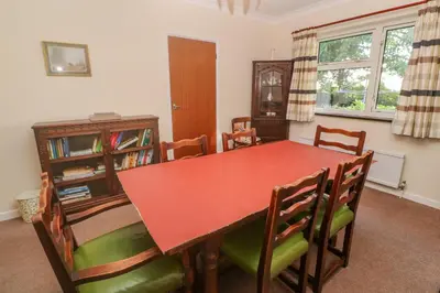 a dining room with a red table and chairs at Yngywidden in Penzance