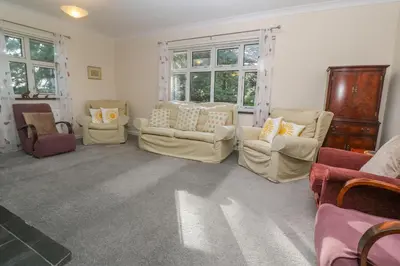 a living room with couches and chairs and windows at Yngywidden in Penzance