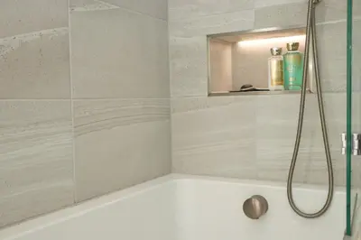 a bathroom with a bath tub with a shower at Stunning home, sea views, walk to beach in Saint Ervan