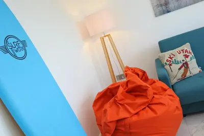 a living room with a surfboard and a blue couch at Stunning home, sea views, walk to beach in Saint Ervan