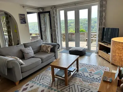 a living room with a couch and a table at Looe, Cornwall, couples, families, quiet location, views, reliable Wi-Fi, modern cottage in Looe